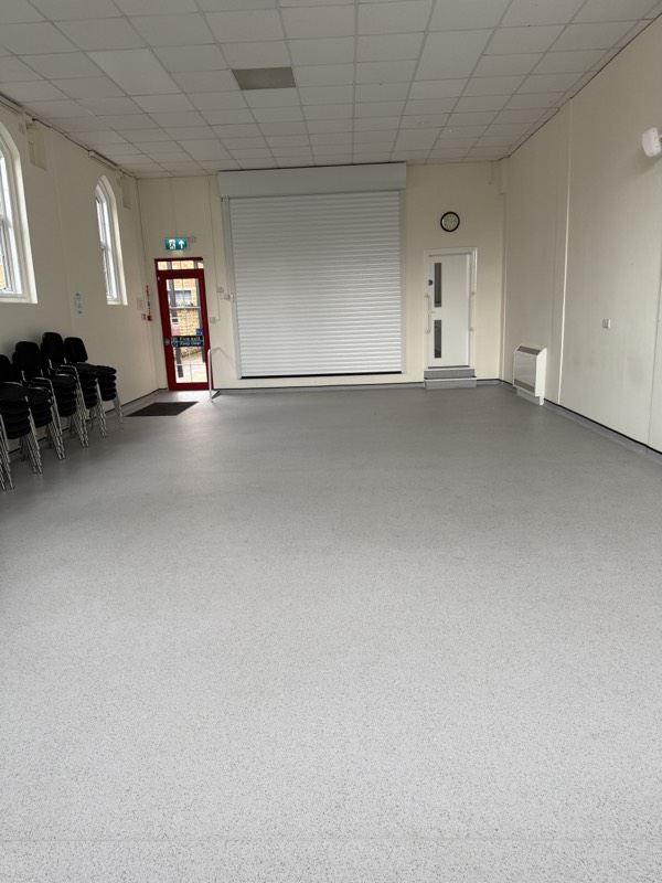 The main hall, empty, with the roller shutter down across one end