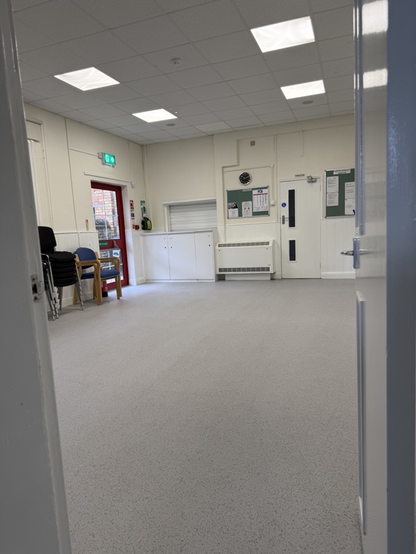 The small hall, with the kitchen serving hatch, noticeboards and the door to the toilets